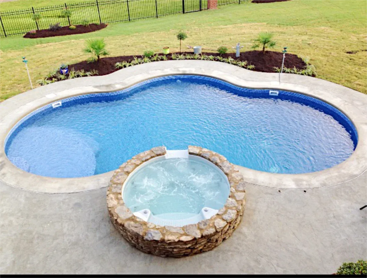 This lagoon pool design features a raised, natural stone spa hot-tub.